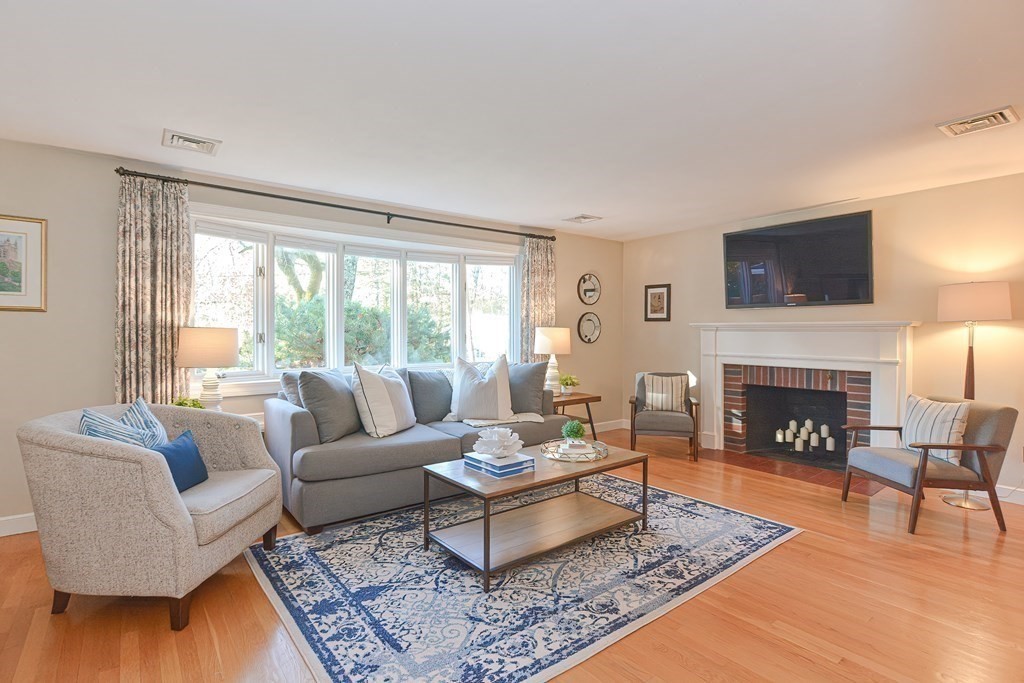 7 Tamarack Road Medfield, MA 02052 - Photo 6 of 33 a living room with furniture a fireplace a flat screen tv and a large window