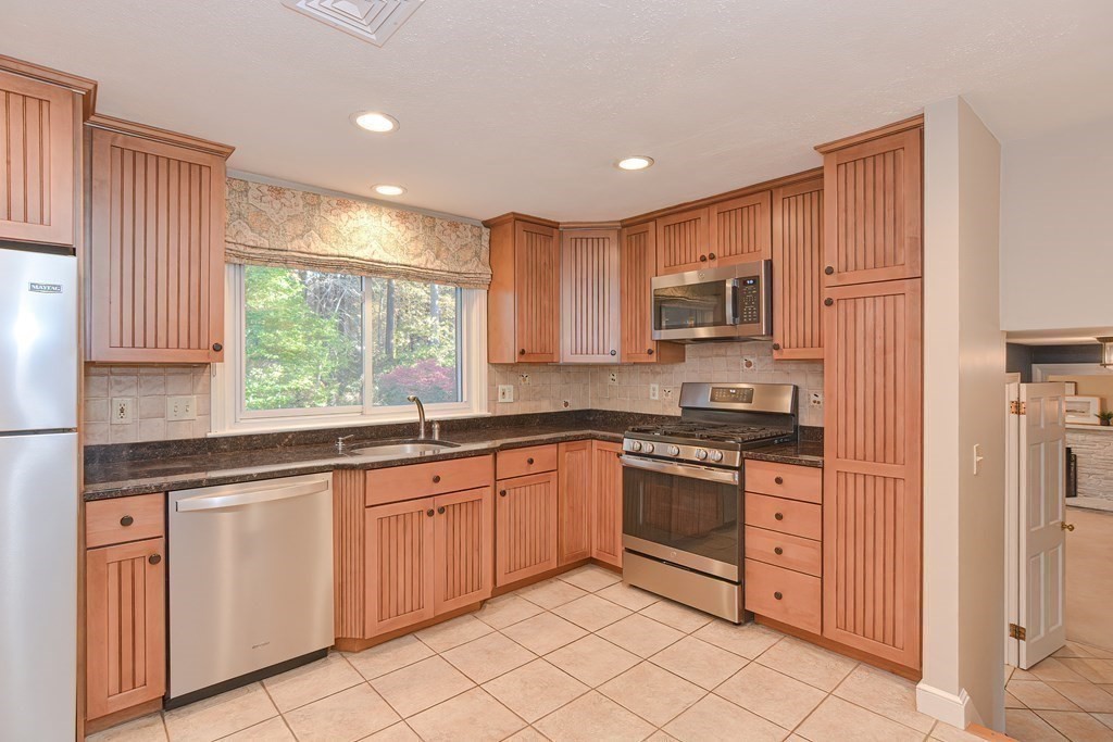 7 Tamarack Road Medfield, MA 02052 - Photo 10 of 33 a kitchen with granite countertop cabinets stainless steel appliances a sink and a window