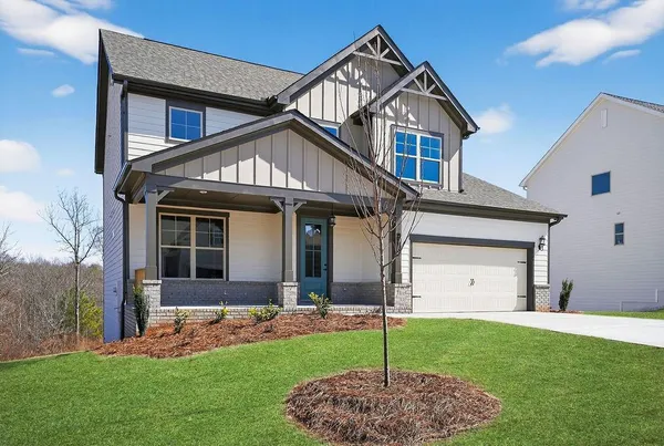 a front view of a house with a garden and yard