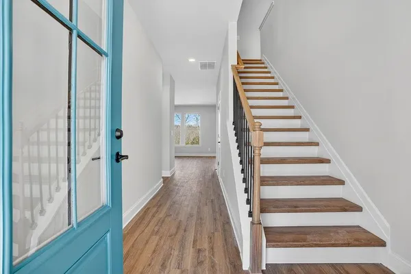 a view of a hallway with wooden floor and windows