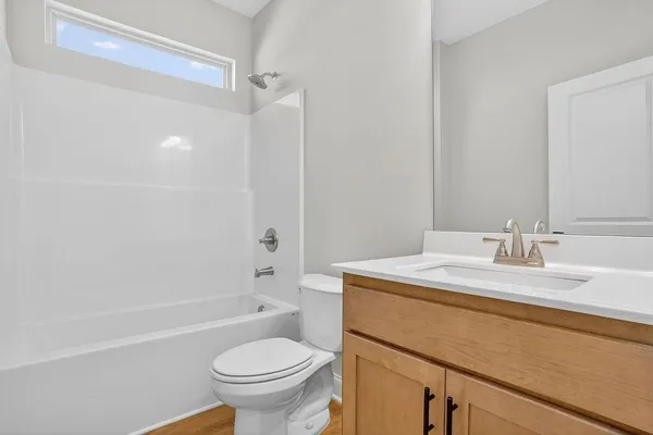 a bathroom with a granite countertop sink toilet mirror vanity and shower