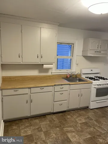 a kitchen with granite countertop a sink and cabinets