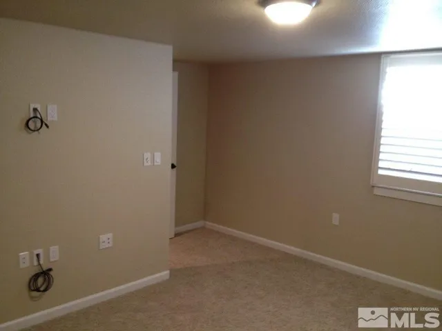an empty room with closet and a chandelier fan