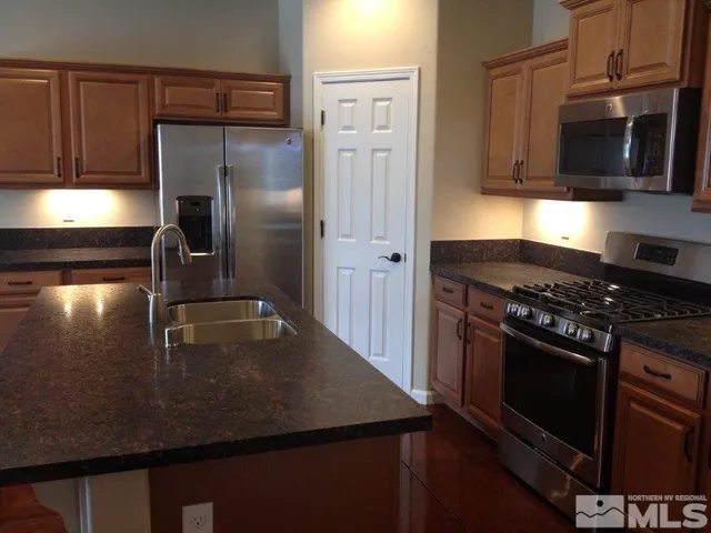 a kitchen with stainless steel appliances granite countertop a sink stove and refrigerator