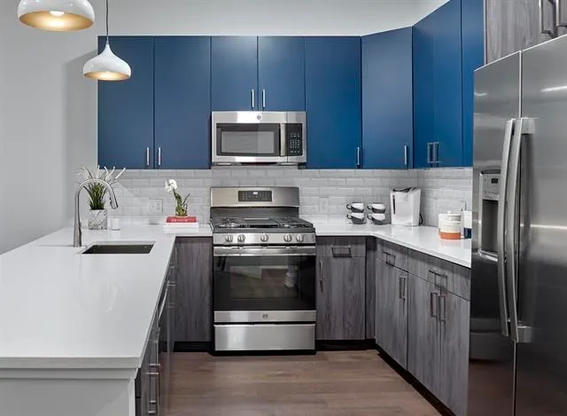 a kitchen with stainless steel appliances a stove a microwave and a refrigerator