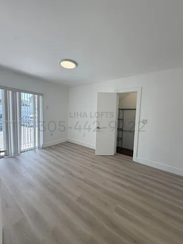 a view of empty room with wooden floor and window