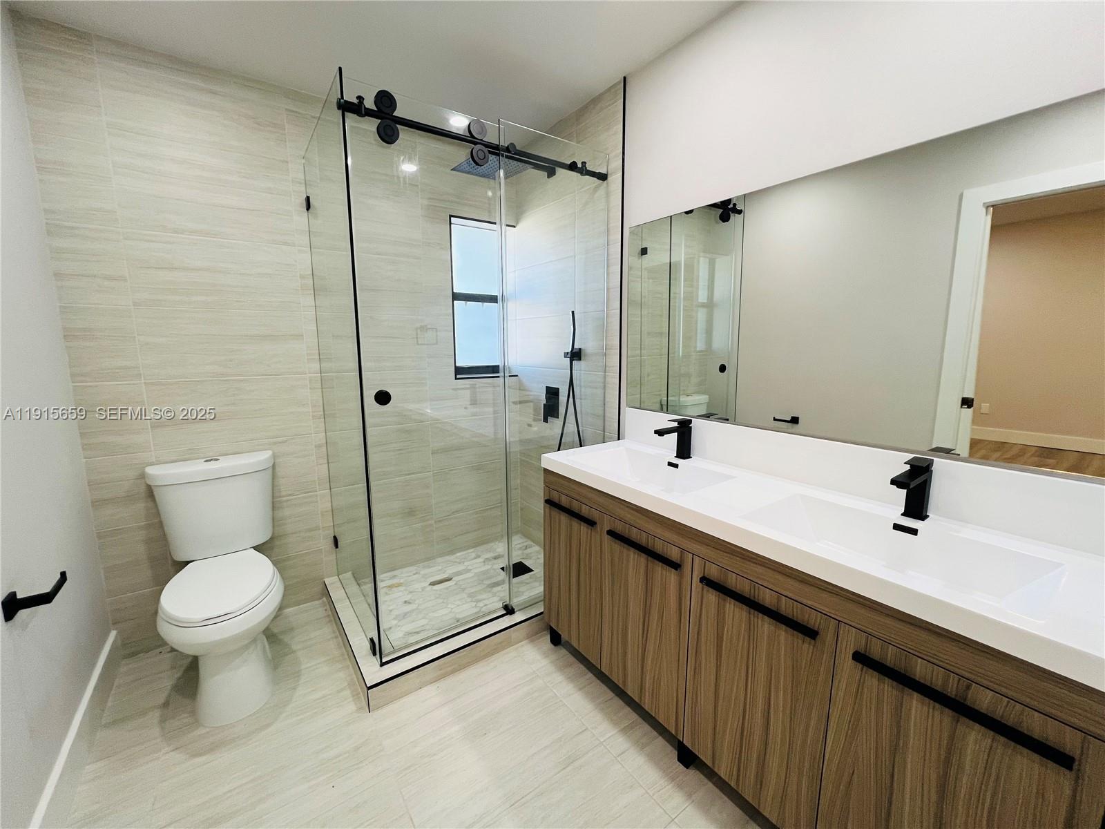 3826 Southwest 107th Avenue, Unit 22 Miami, FL 33165 - Photo 16 of 18 a bathroom with a sink toilet a mirror and shower