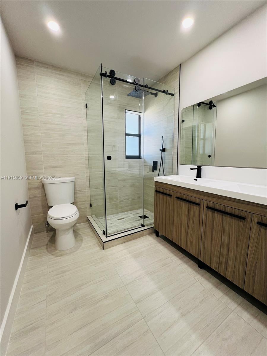 3826 Southwest 107th Avenue, Unit 22 Miami, FL 33165 - Photo 17 of 18 a bathroom with a double vanity sink toilet and a mirror