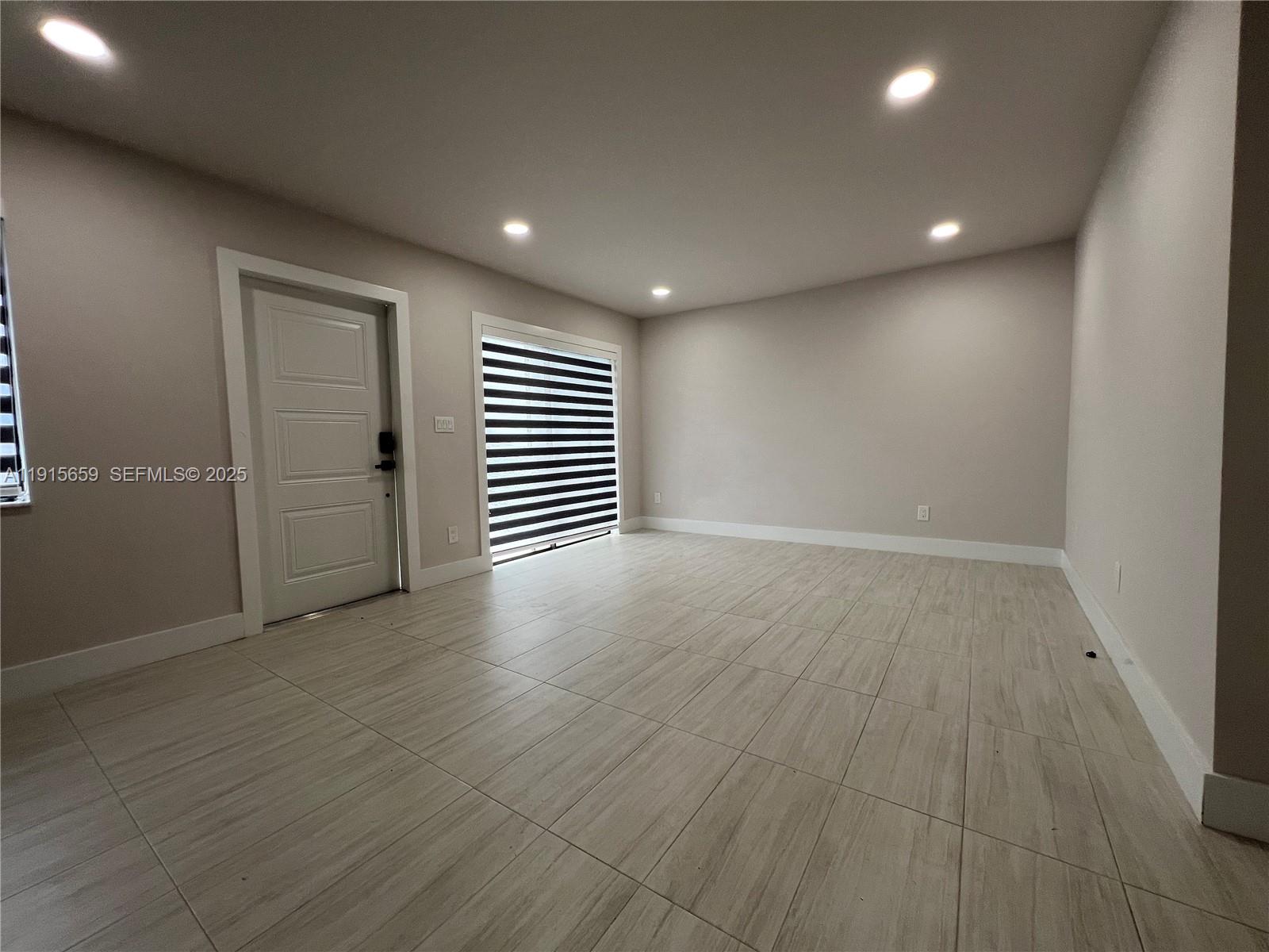 3826 Southwest 107th Avenue, Unit 22 Miami, FL 33165 - Photo 10 of 18 an empty room with wooden floor and windows