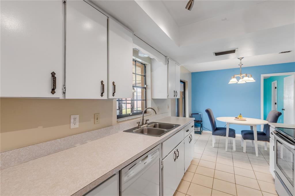 26 Laughing Gull Lane Edgewater, FL 32141 - Photo 22 of 66 a kitchen with a sink and chairs