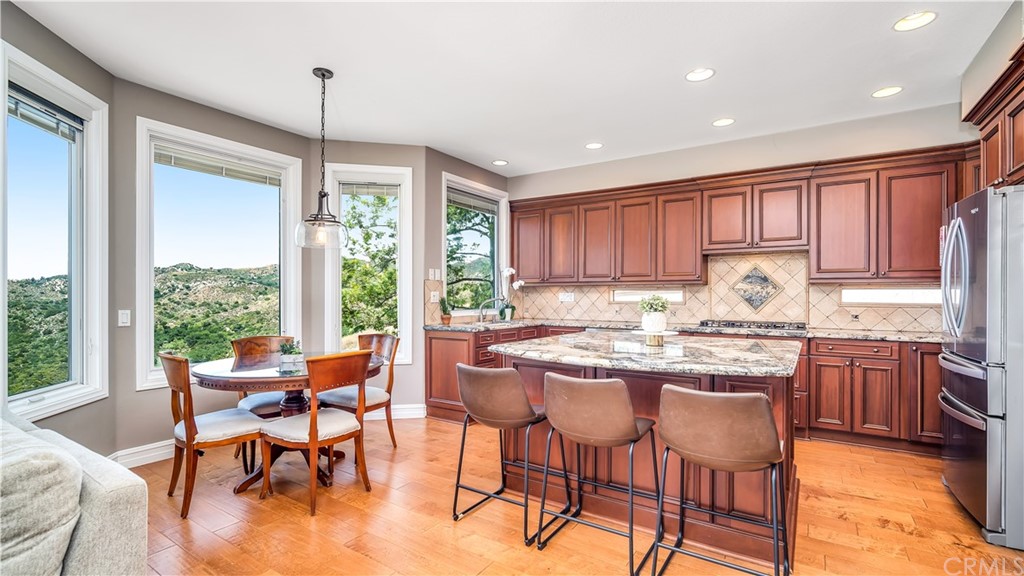28565 Cedar Ridge Road Lake Forest, CA 92679 - Photo 1 of 1 a kitchen with granite countertop wooden cabinets dining table and chairs