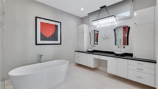 a bathroom with a granite countertop sink mirror and bathtub