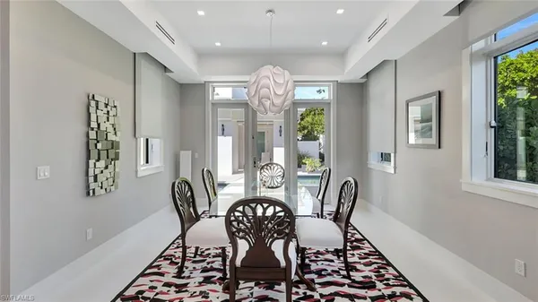 a view of a dining room with furniture a chandelier and wooden floor
