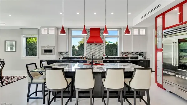 a kitchen with a dining table chairs and white cabinets