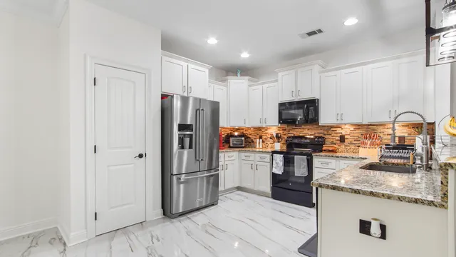 a kitchen with granite countertop stainless steel appliances and wooden cabinets