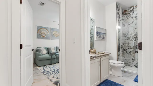 a white toilet sitting next to a bathroom sink and a shower