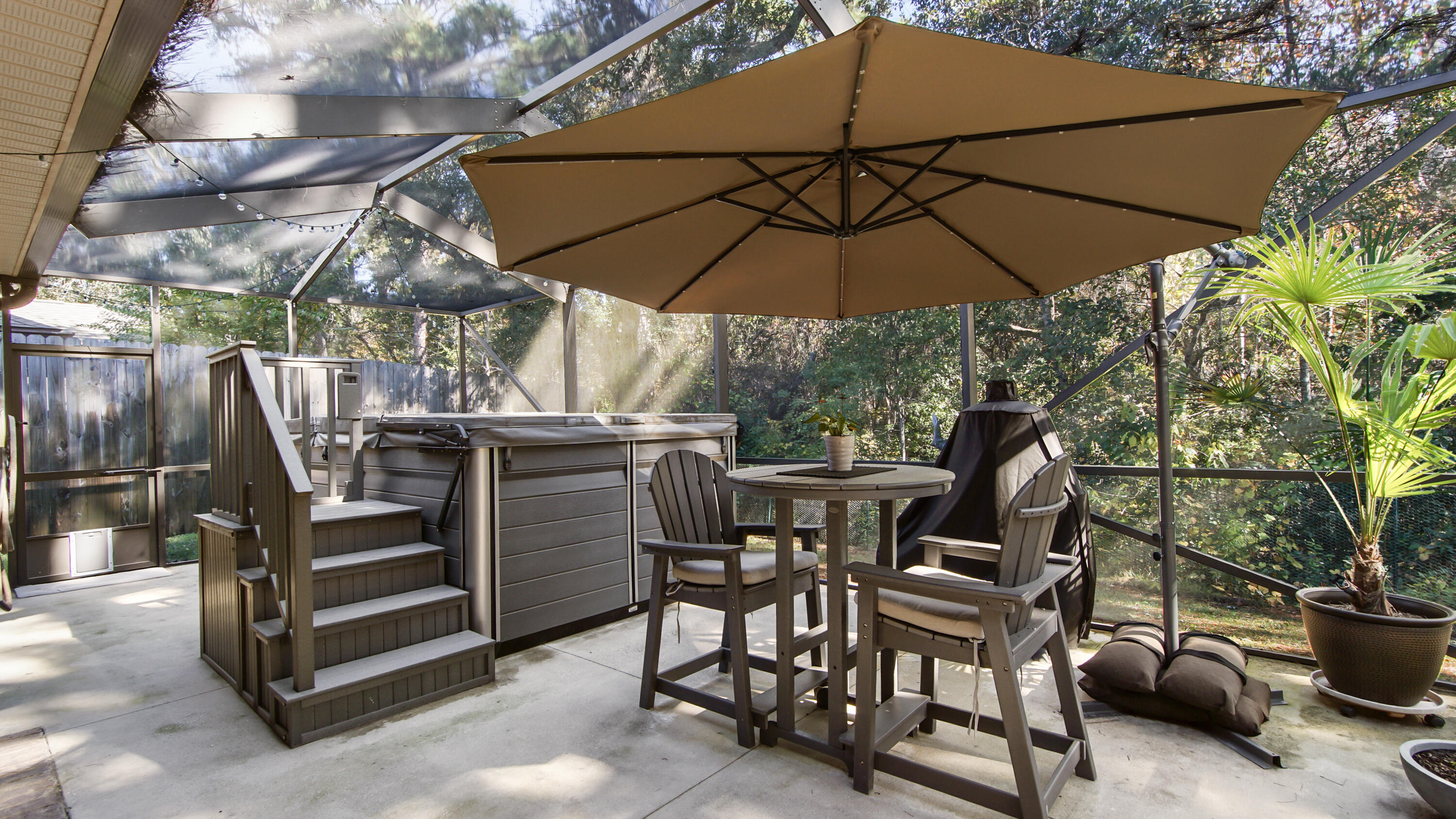 123 Big Oak Lane Santa Rosa Beach, FL 32459 - Photo 34 of 50 a view of a patio with table and chairs under an umbrella