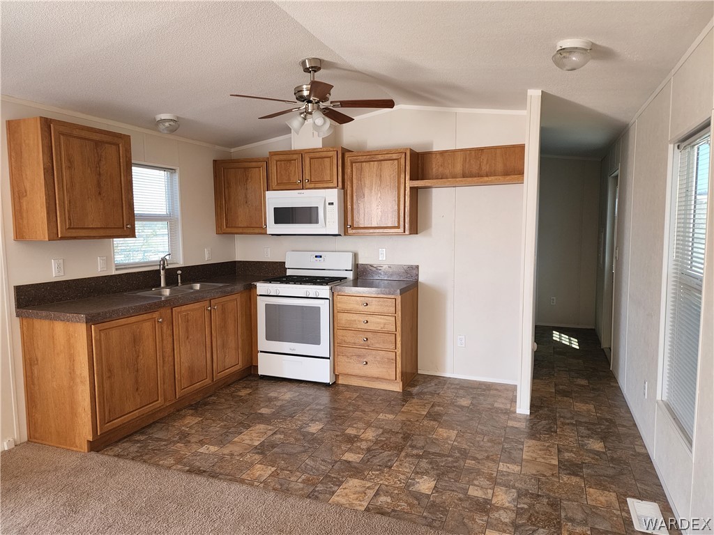 2066 East El Rodeo Road, Unit 31 Fort Mohave, AZ 86426 - Photo 4 of 12 a kitchen with granite countertop a sink cabinets stainless steel appliances and a window