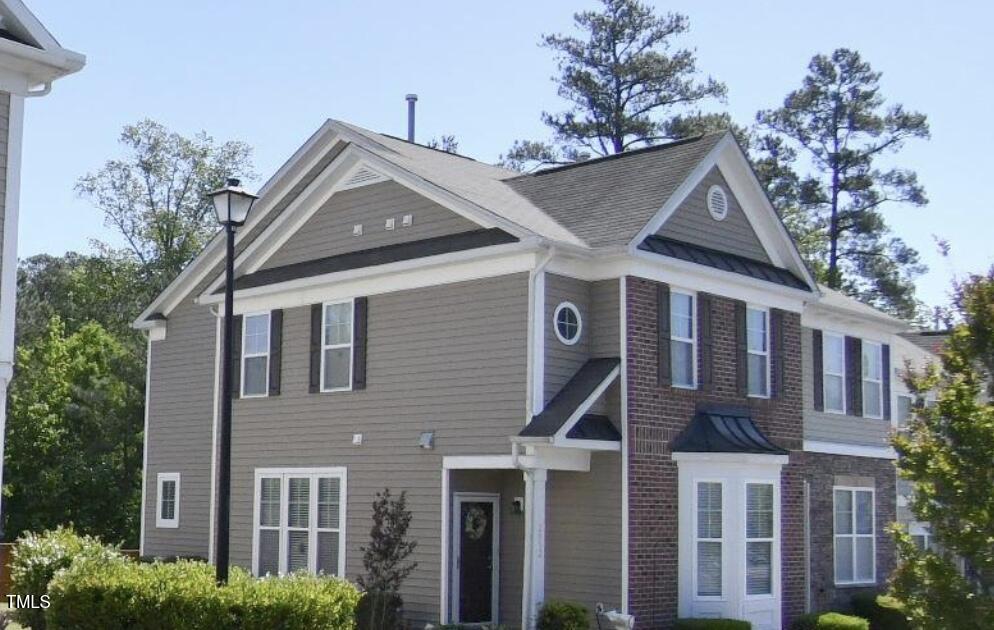 a view of a house with a yard and potted plants