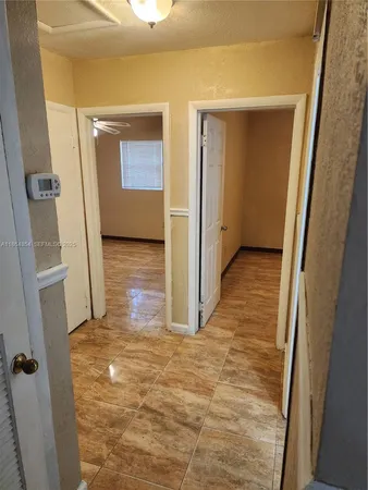 a view of a hallway with wooden walls and door