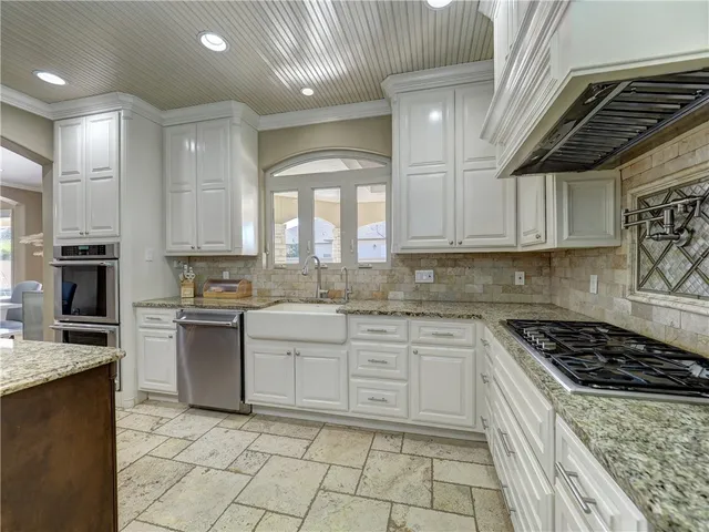 a kitchen with granite countertop a sink a stove and a refrigerator