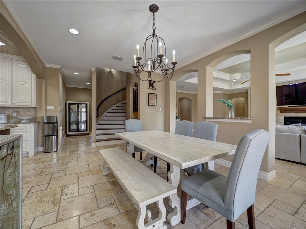 204 Black Diamond Road Portland, TX 78374 - Photo 9 of 40 a dining room with wooden floor a chandelier a wooden table and chairs