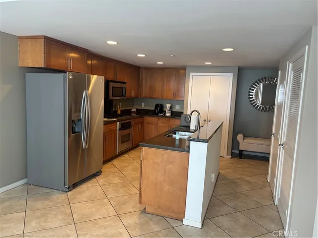 a kitchen with stainless steel appliances granite countertop a refrigerator and a stove