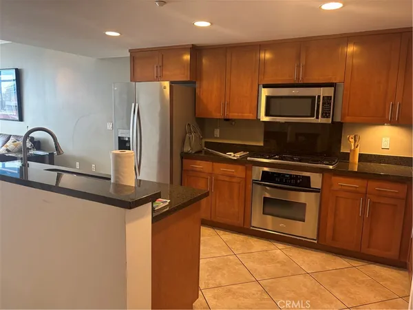 a kitchen with kitchen island granite countertop a sink cabinets and stainless steel appliances