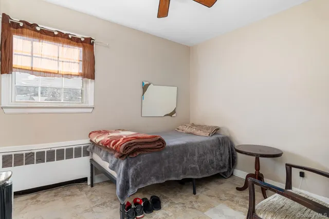 a bedroom with a bed a window and dresser