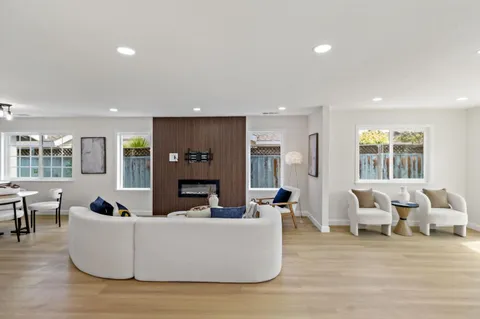 a kitchen with stainless steel appliances a stove top oven a sink a dining table and chairs