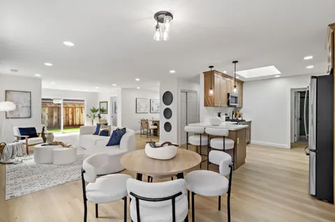 a kitchen with a dining table chairs and refrigerator