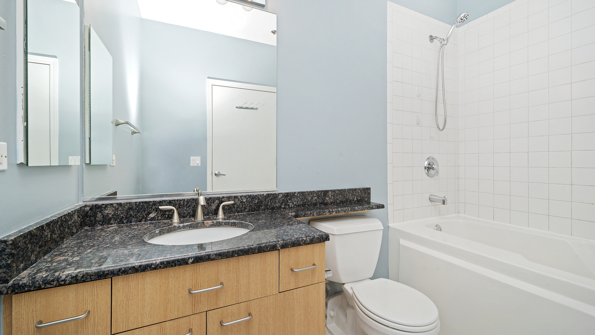 1301 West Madison Street, Unit 304 Chicago, IL 60607 - Photo 12 of 15 a bathroom with a granite countertop sink toilet and shower