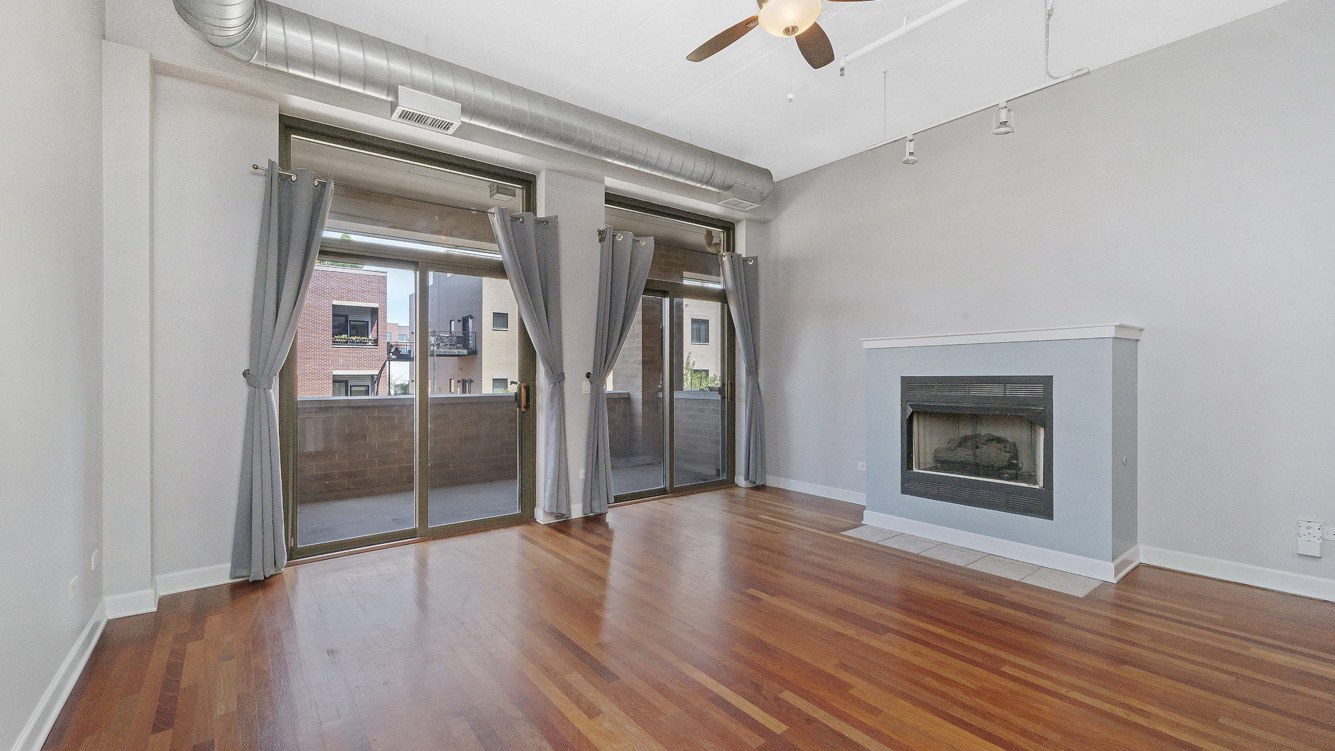 1301 West Madison Street, Unit 304 Chicago, IL 60607 - Photo 4 of 15 an empty room with wooden floor and a ceiling fan