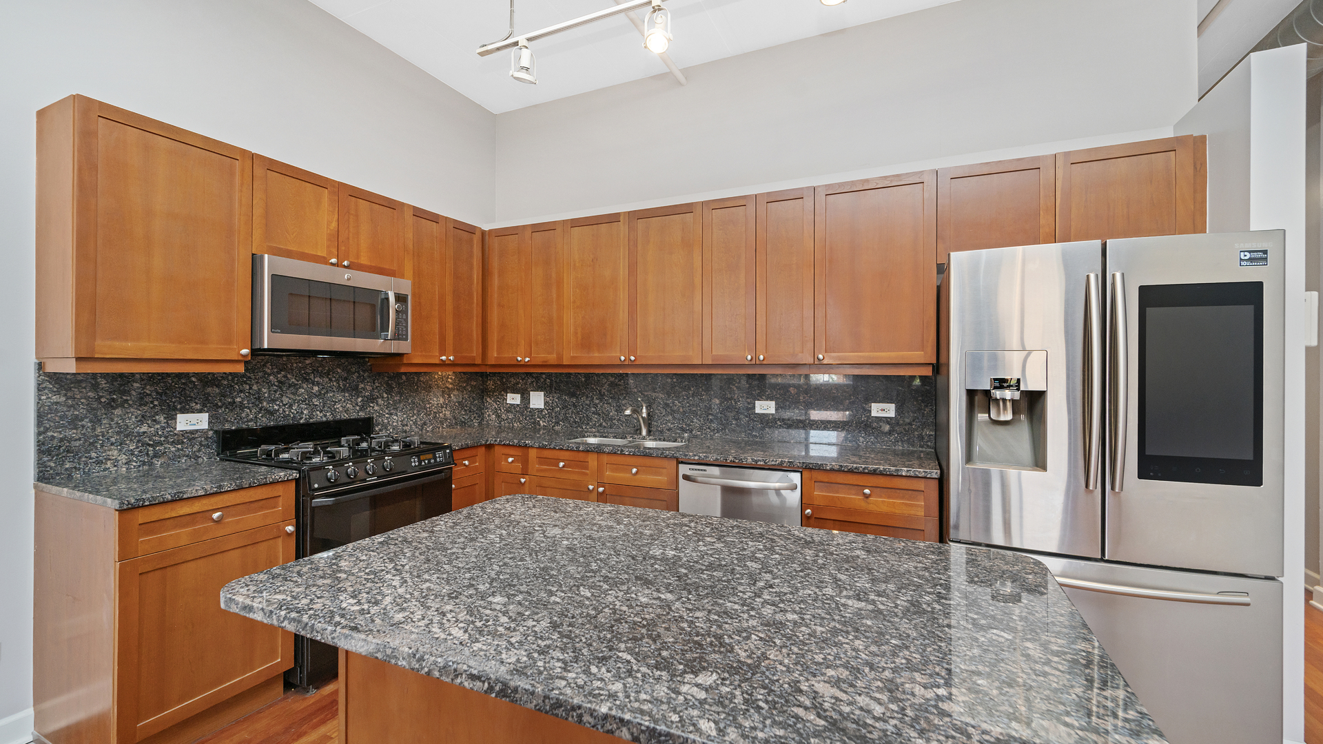 1301 West Madison Street, Unit 304 Chicago, IL 60607 - Photo 8 of 15 a kitchen with stainless steel appliances granite countertop a refrigerator and a stove top oven