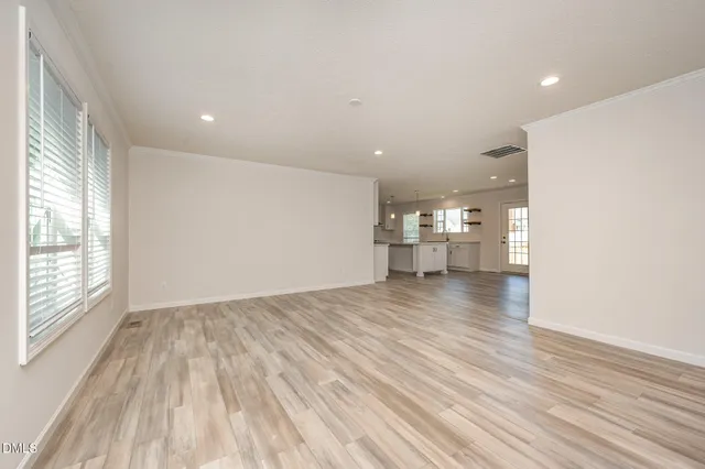 a view of empty room with wooden floor