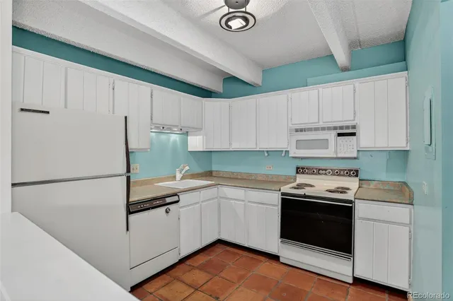 a kitchen with a sink a stove and cabinets