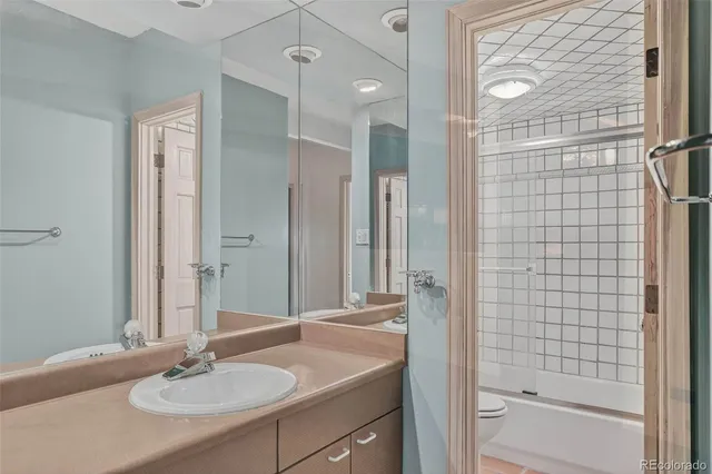 a bathroom with a sink double vanity granite tub shower and a mirror