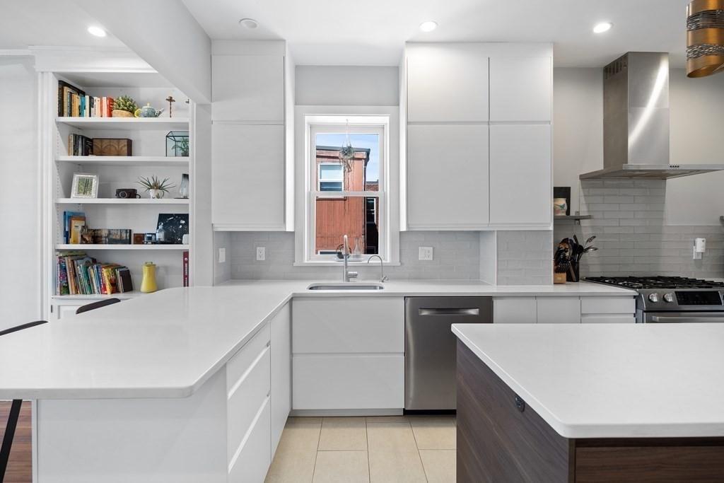 23 Strathmore Road, Unit 3 Brookline, MA 02445 - Photo 13 of 26 a kitchen with a sink a stove a refrigerator and white cabinets