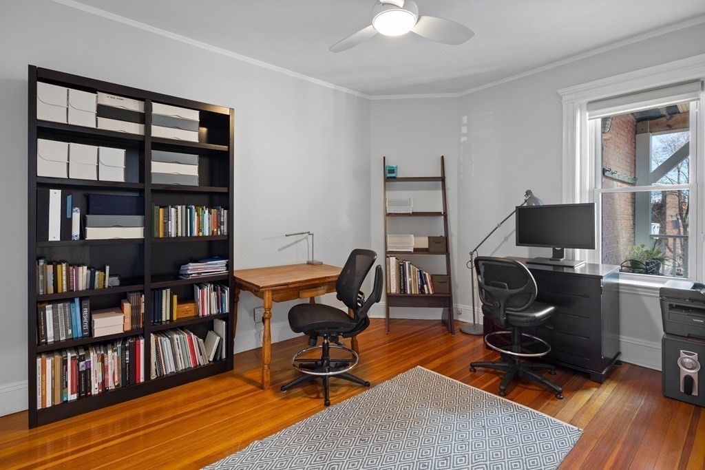 23 Strathmore Road, Unit 3 Brookline, MA 02445 - Photo 17 of 26 a view of a workspace with furniture and a bookshelf