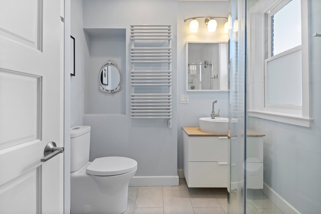 23 Strathmore Road, Unit 3 Brookline, MA 02445 - Photo 18 of 26 a bathroom with a toilet sink and mirror