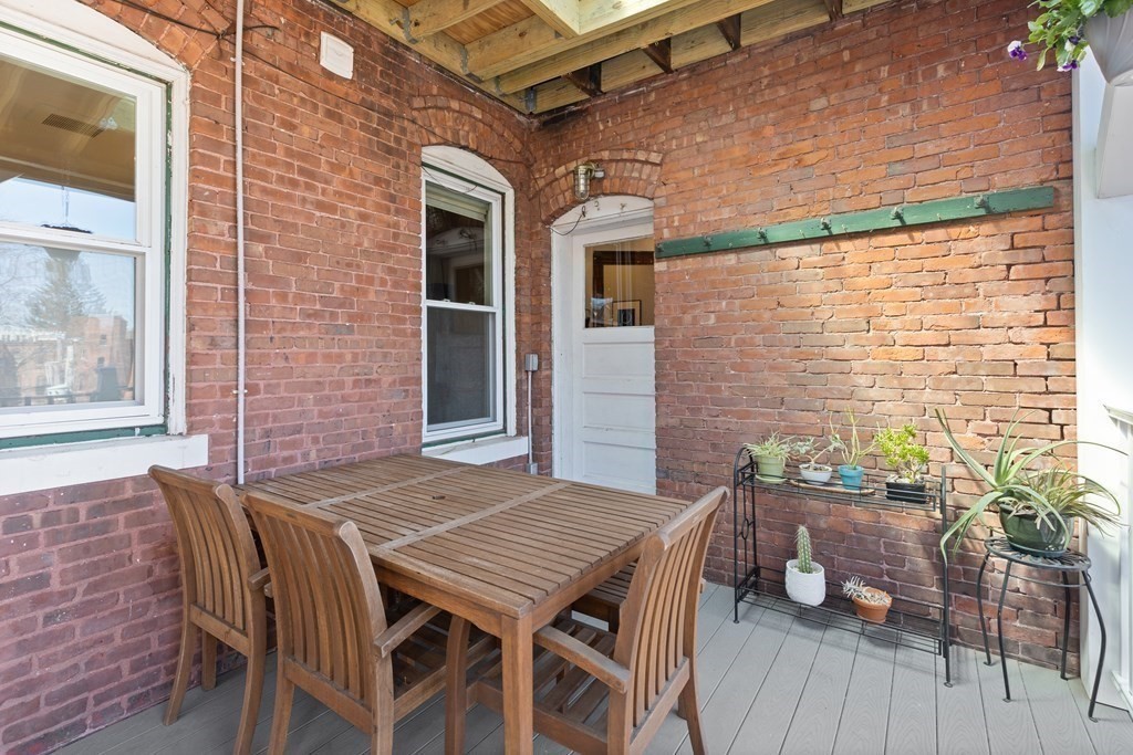 23 Strathmore Road, Unit 3 Brookline, MA 02445 - Photo 20 of 26 a view of a patio with table and chairs with wooden floor and fence