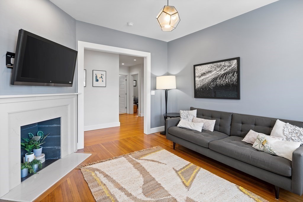 23 Strathmore Road, Unit 3 Brookline, MA 02445 - Photo 4 of 26 a living room with furniture a flat screen tv and a fireplace