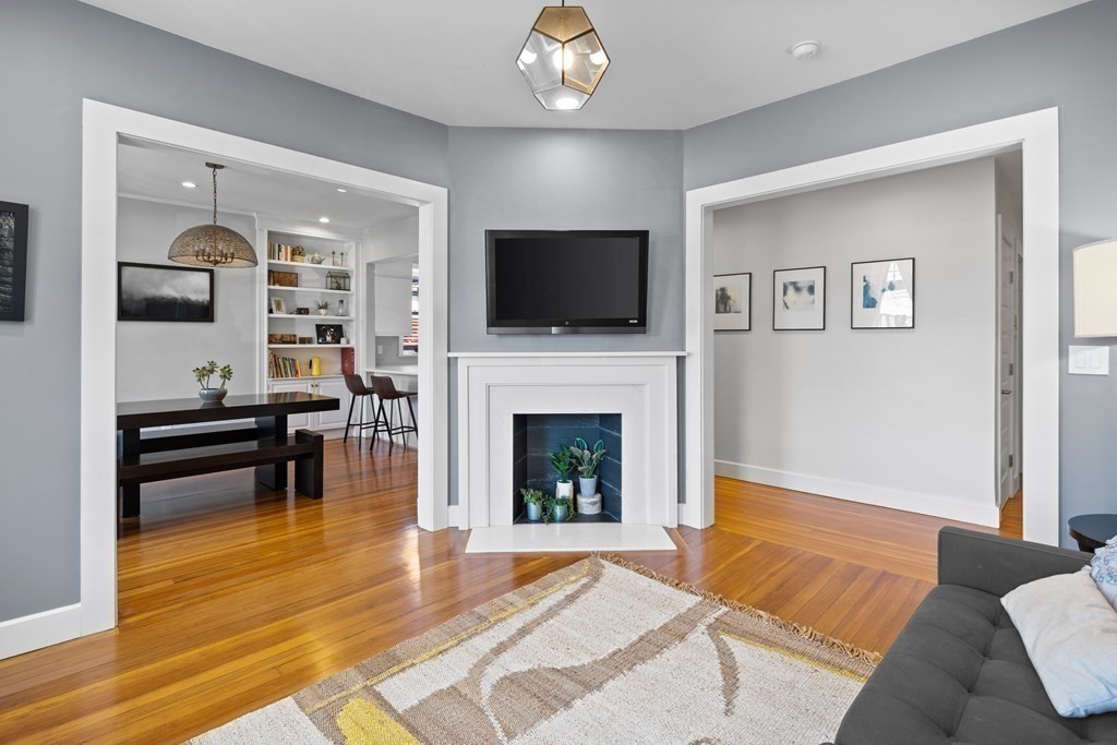 23 Strathmore Road, Unit 3 Brookline, MA 02445 - Photo 5 of 26 a living room with furniture a flat screen tv and a fireplace