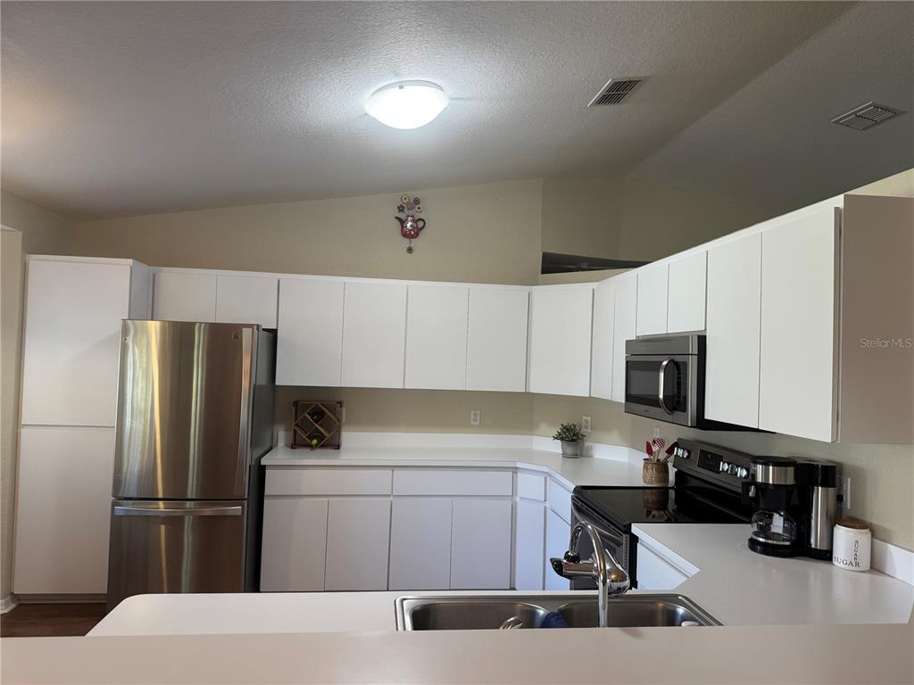 6071 Southwest 105th Place Ocala, FL 34476 - Photo 4 of 13 a kitchen with a refrigerator a stove and a sink