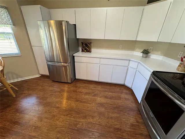 a kitchen with a refrigerator sink and cabinets