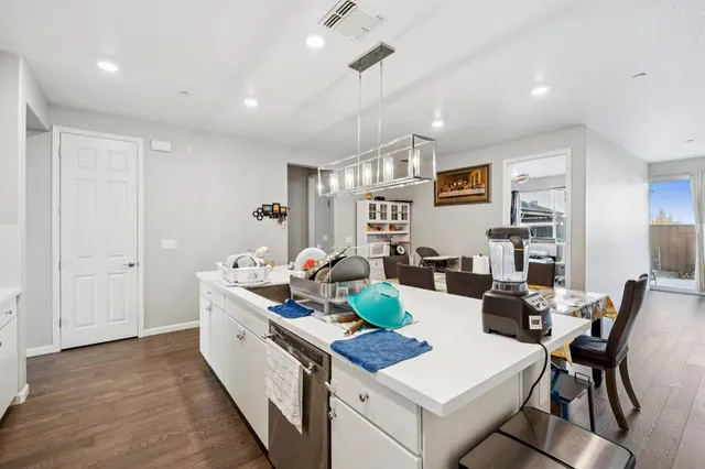 a kitchen with a dining table chairs and refrigerator