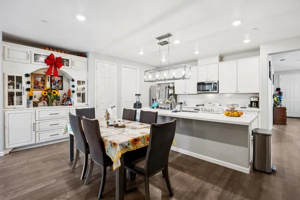 a view of a dining room and livingroom with furniture wooden floor a chandelier