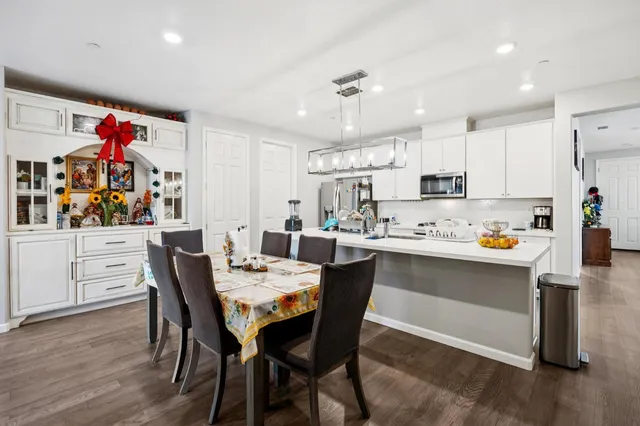 a view of a dining room and livingroom with furniture wooden floor a chandelier