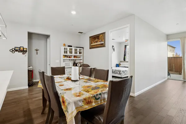 a view of a dining room with furniture a kitchen and chandelier