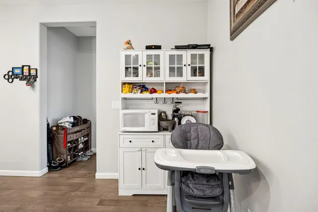 a kitchen with stainless steel appliances a table chairs refrigerator and wooden floor